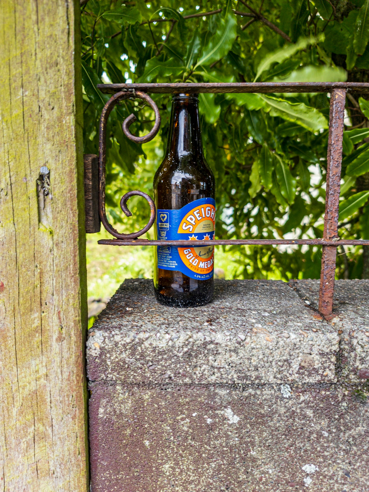 a bottle of beer sitting on top of a cement block