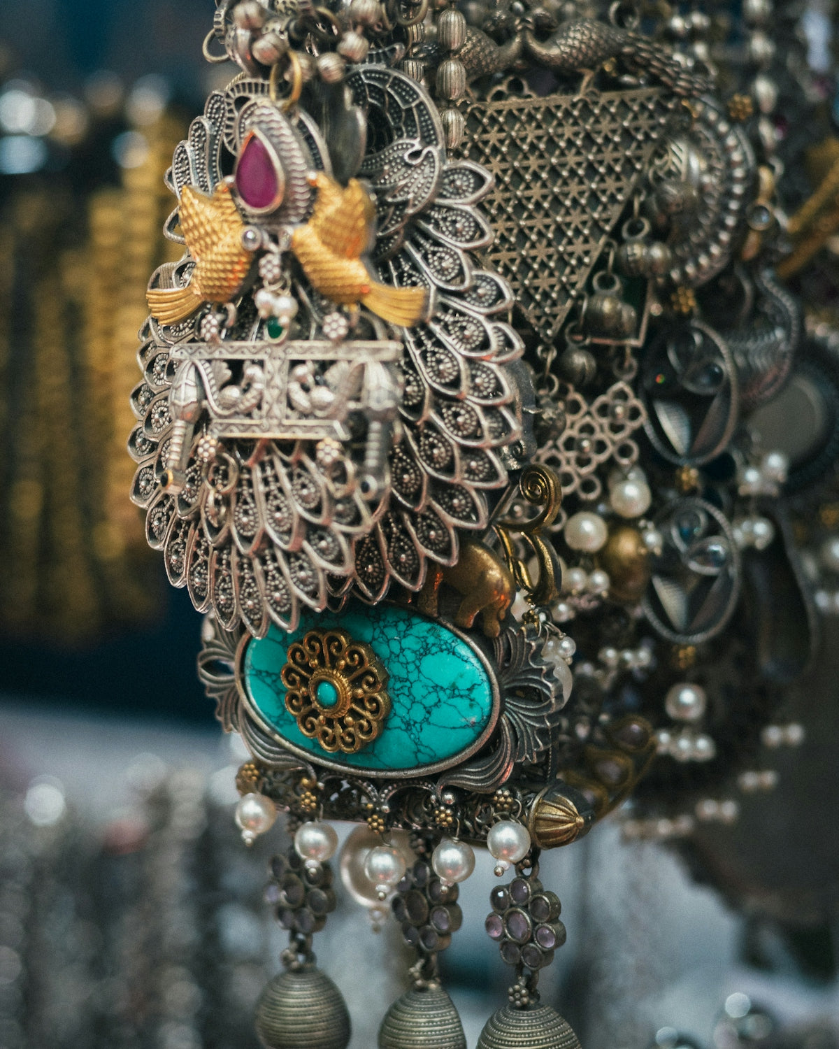 Intricate silver jewelry with turquoise and pearl accents.