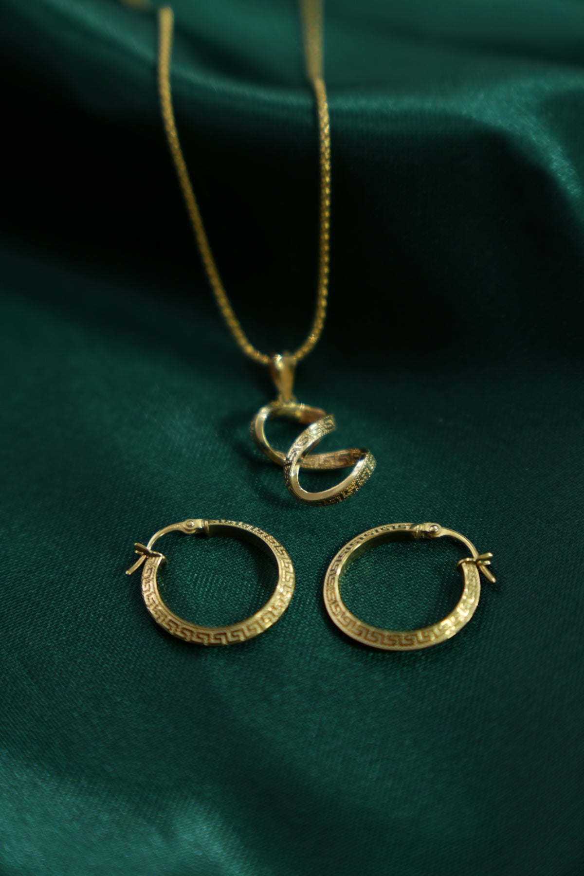 Gold snake pendant necklace and hoop earrings