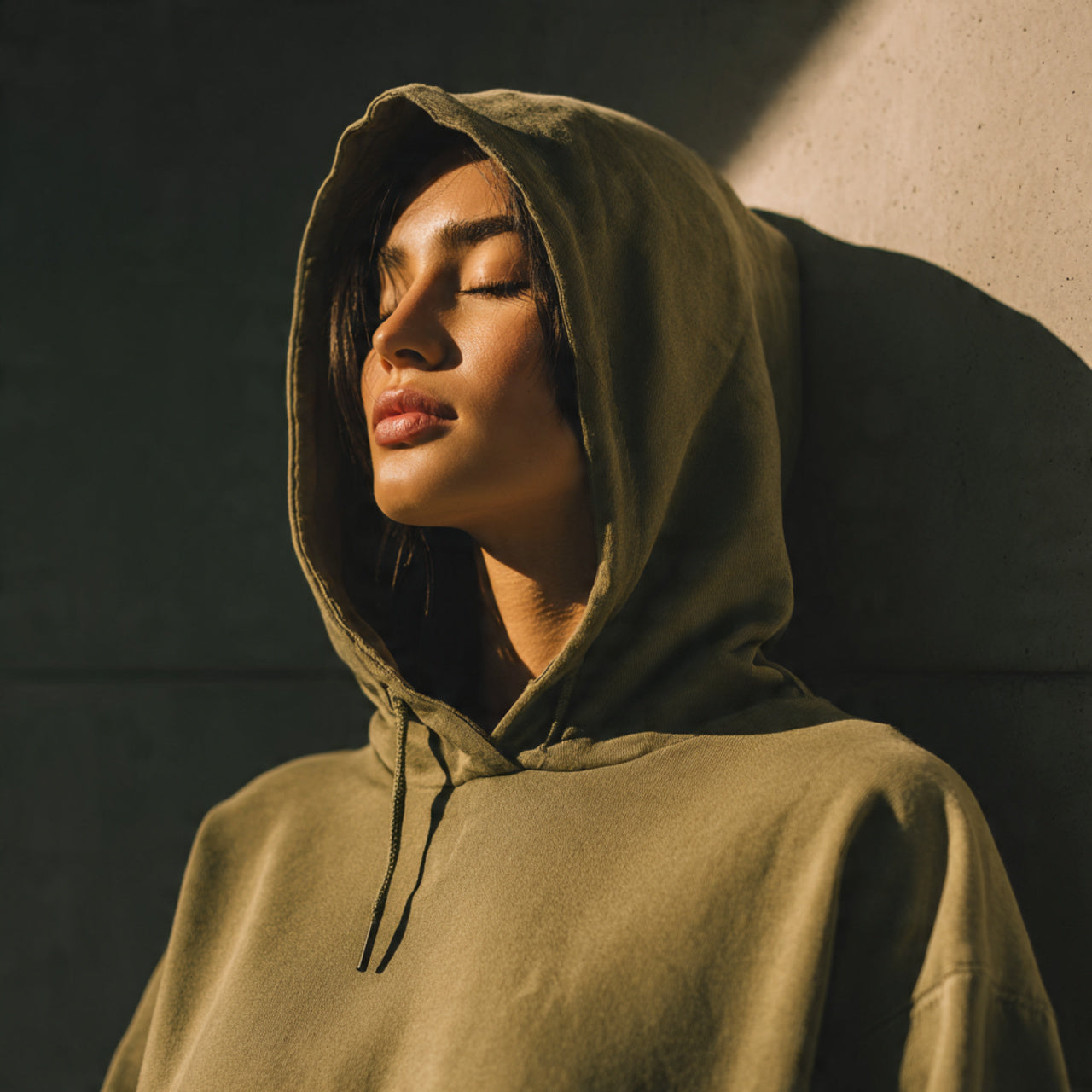 Urban chic female model wearing a premium hoodie, soft matte lighting, minimal modern background, high-end streetwear aesthetic, clean composition, editorial style